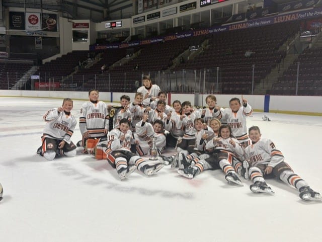 The Compuware team poses on the ice with the championship trophy