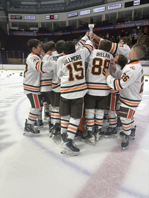 Compuware players lift the championship trophy together on the ice